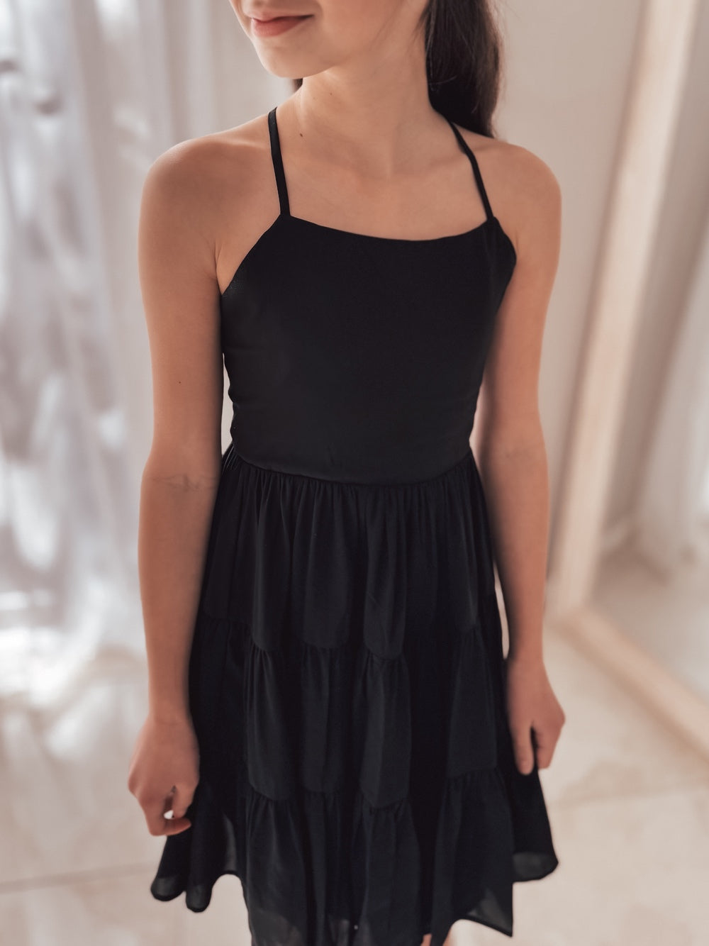 Front view of Phoebe Girls Black Graduation Dress – knee-length chiffon dress with tie-up back