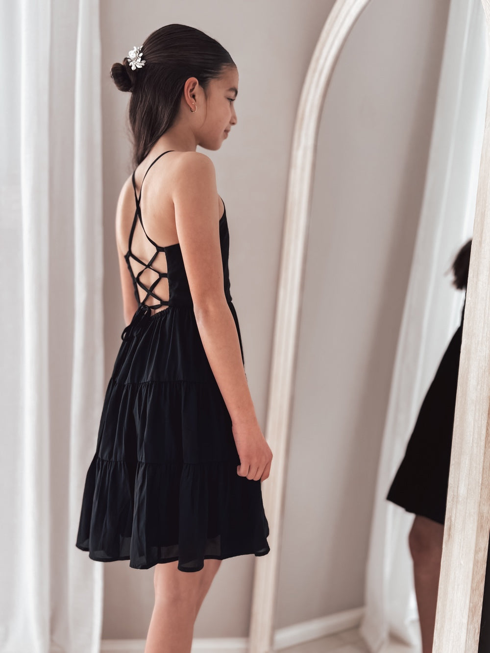 Formal girls black dress styled with sparkling headpiece for graduation