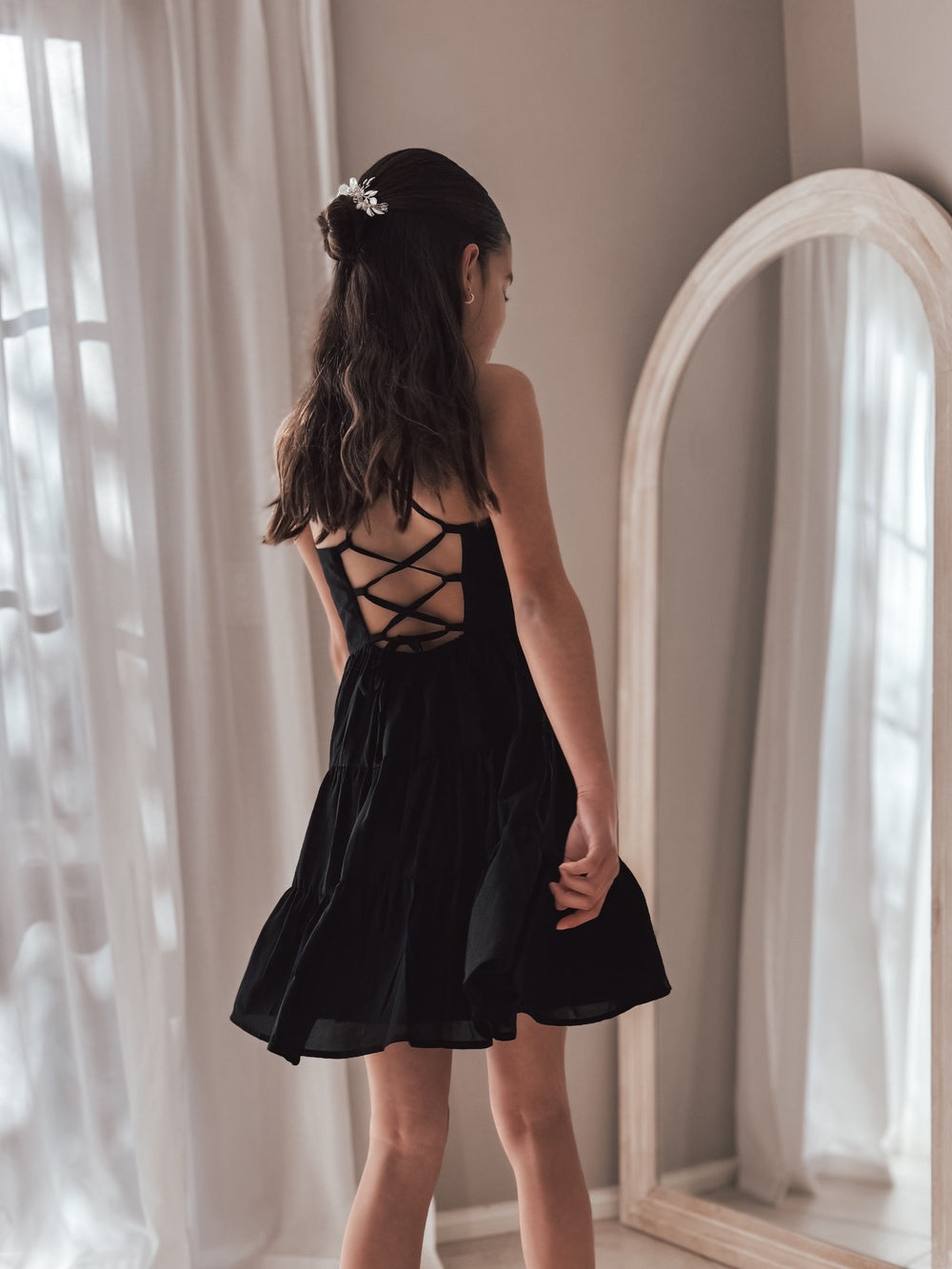 Back view of Phoebe Girls Black Graduation Dress showing adjustable lace-up back detail