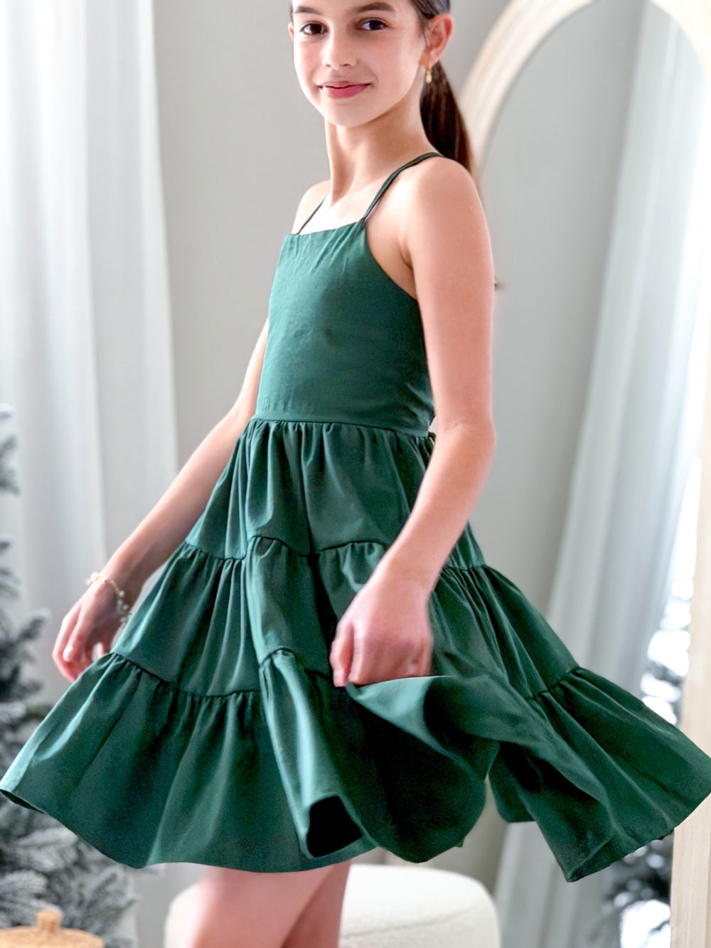 Phoebe Girls Dress - Green - New ArrivalsGirl wearing Phoebe Girls Green Christmas Dress twirling under the Christmas tree