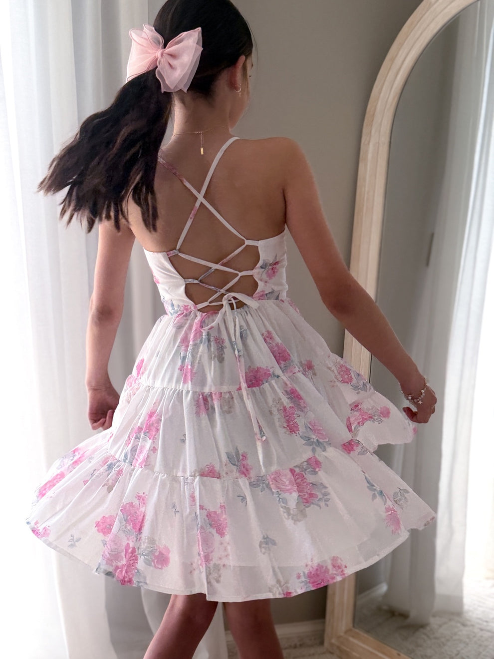 Pink floral tween dress styled with delicate accessories for graduation photos