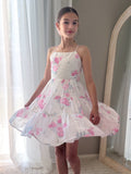 Girl twirling in pink floral chiffon dress at school graduation ceremony