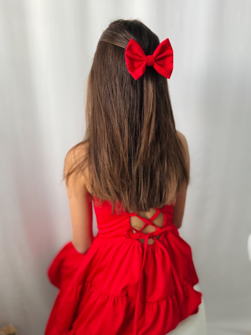 Red party dress with a lace-up back styled for girls' Christmas event