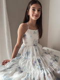 Tween girl sitting in Phoebe Blue Floral primary school graduation dress with skirt fanned out