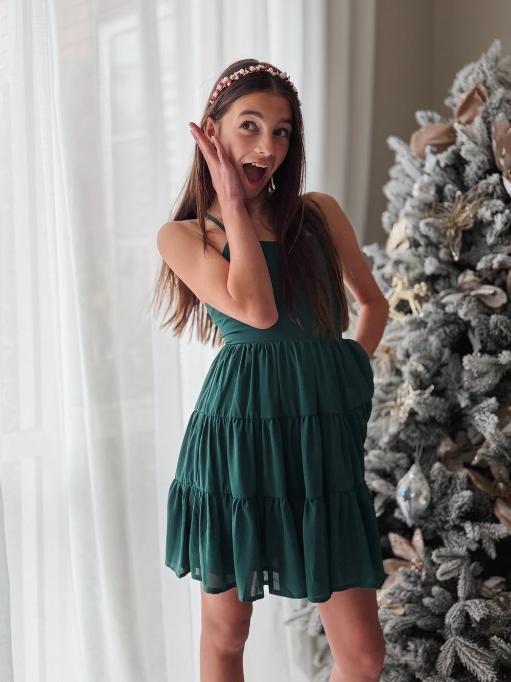 Evergreen girls festive dress beside Christmas tree