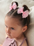 Soft pink bow clips for pigtail hairstyles