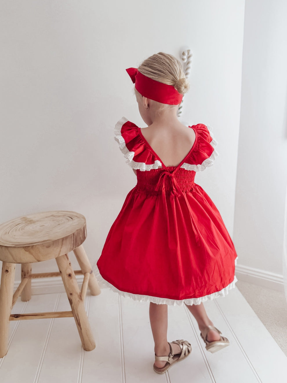 Back view of the Rosie red Christmas dress showing ruffled shoulders, a tie-up back and a shirred panel