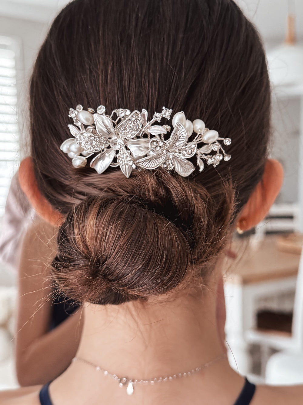 Close-up of silver floral hair comb with white pearls and crystals
