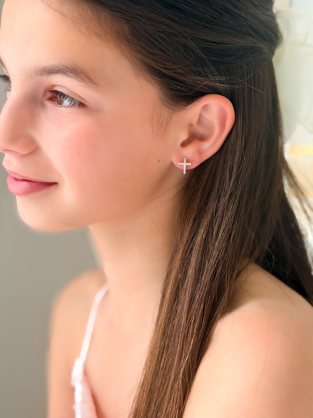 Close-up of Girls Silver Cross Earrings showing sparkling diamante cross detail on silver hoops