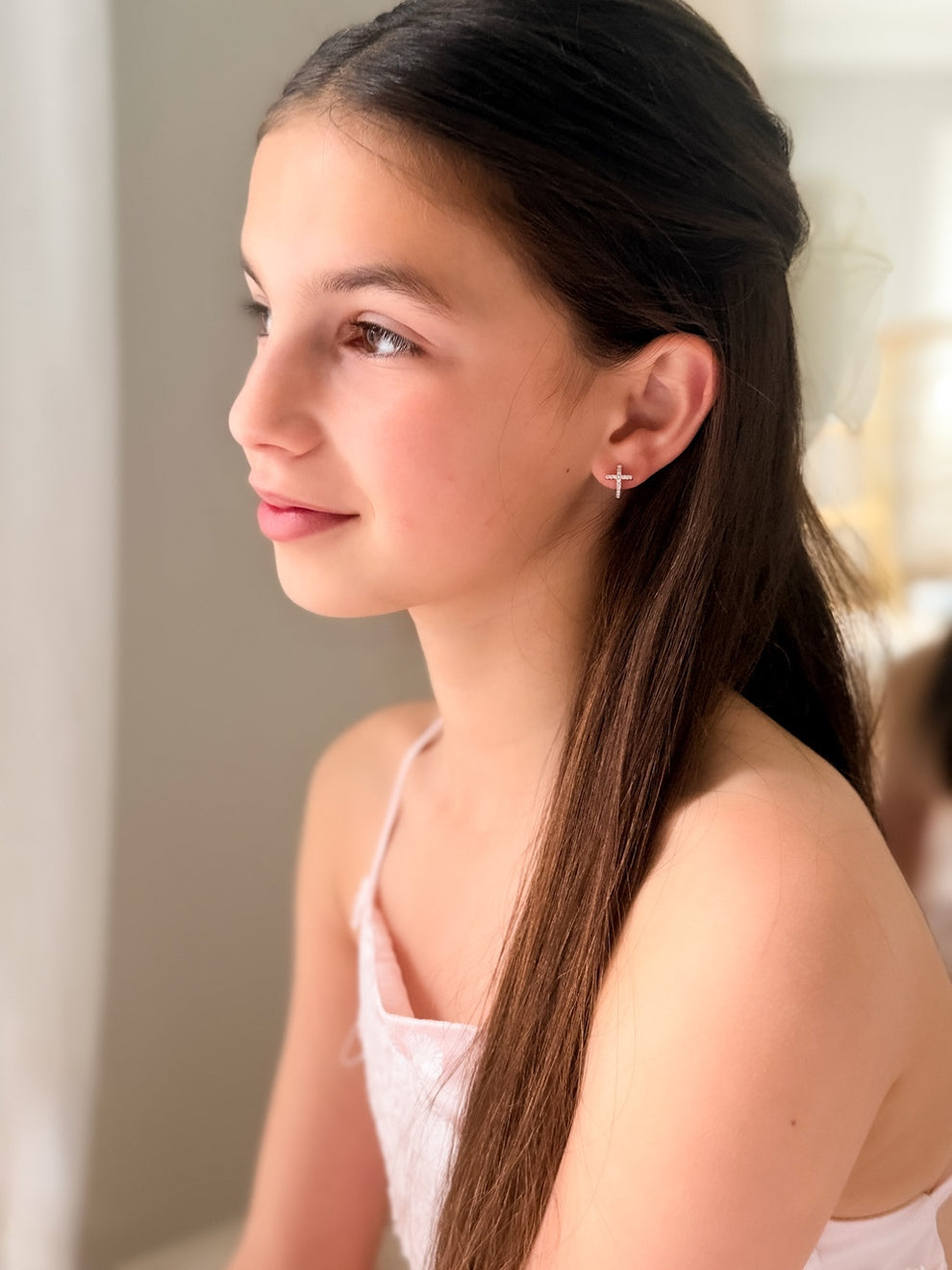 Close-up of diamante cross charms on Girls Silver Earrings – elegant design for special occasions