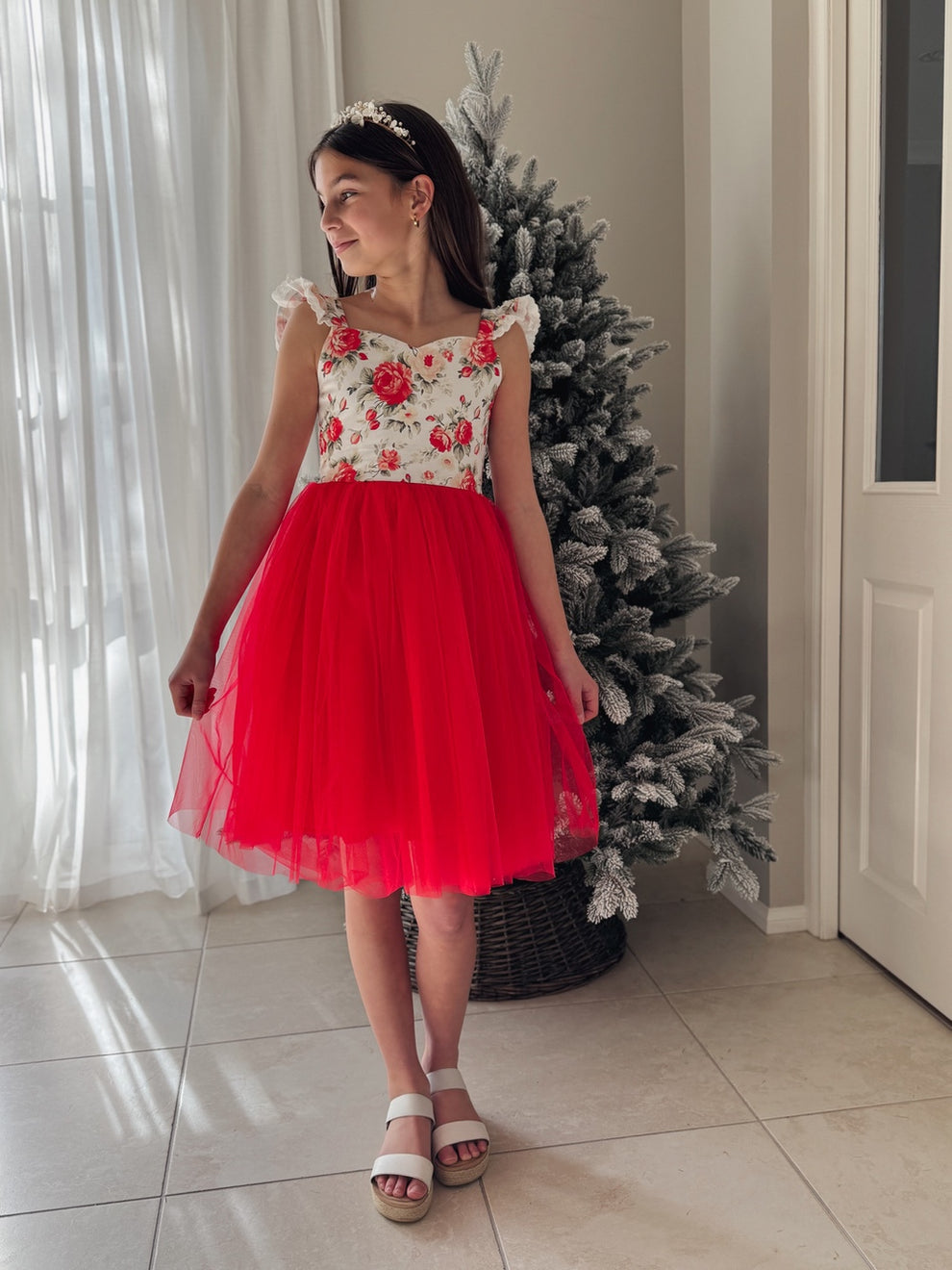 Girl wearing red floral Christmas dress with ruffle shoulders