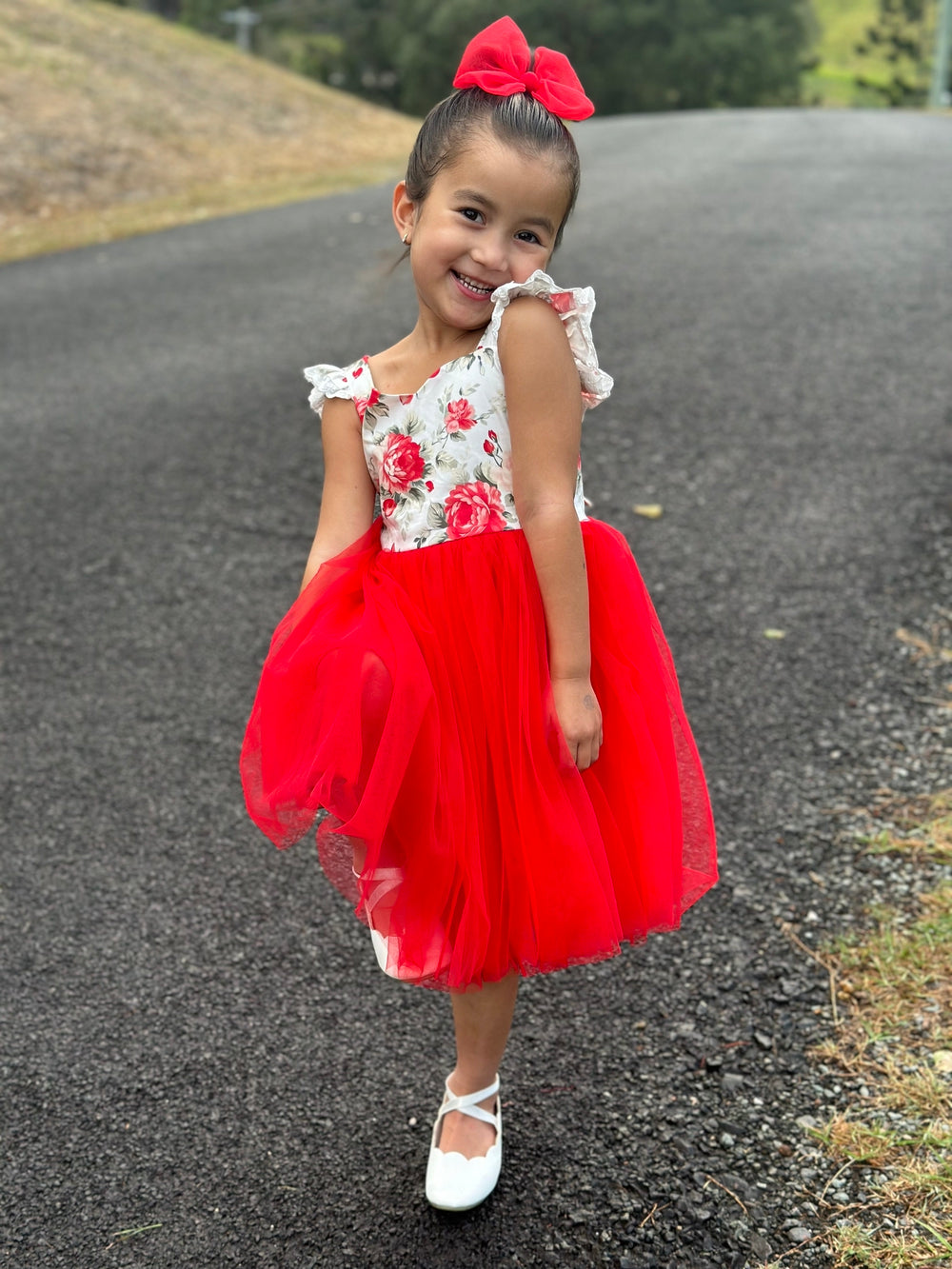 Girl twirling in festive floral tulle dress for Christmas