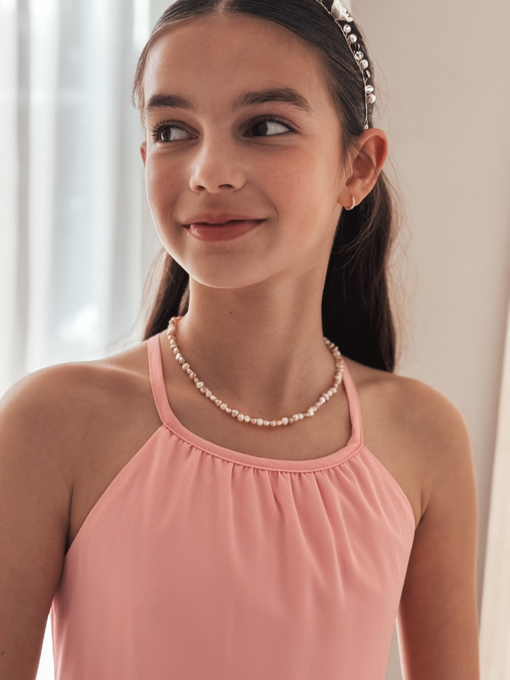 Necklace and bracelet pair displayed on pastel background