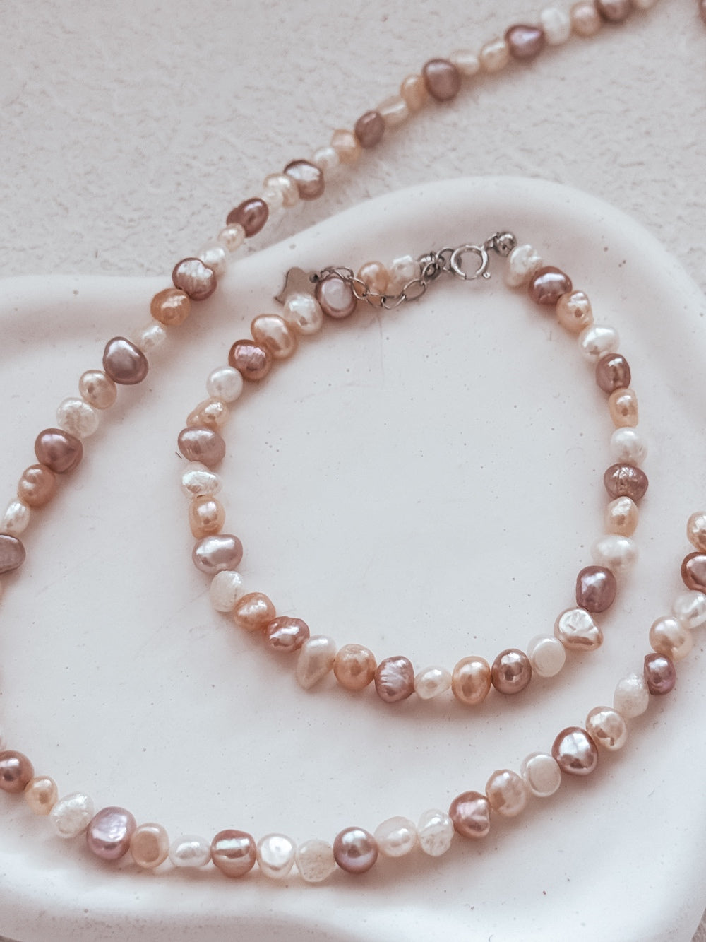 Necklace and bracelet pair displayed on white background