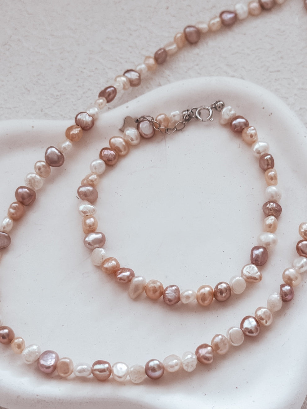 Necklace and bracelet pair displayed on white background