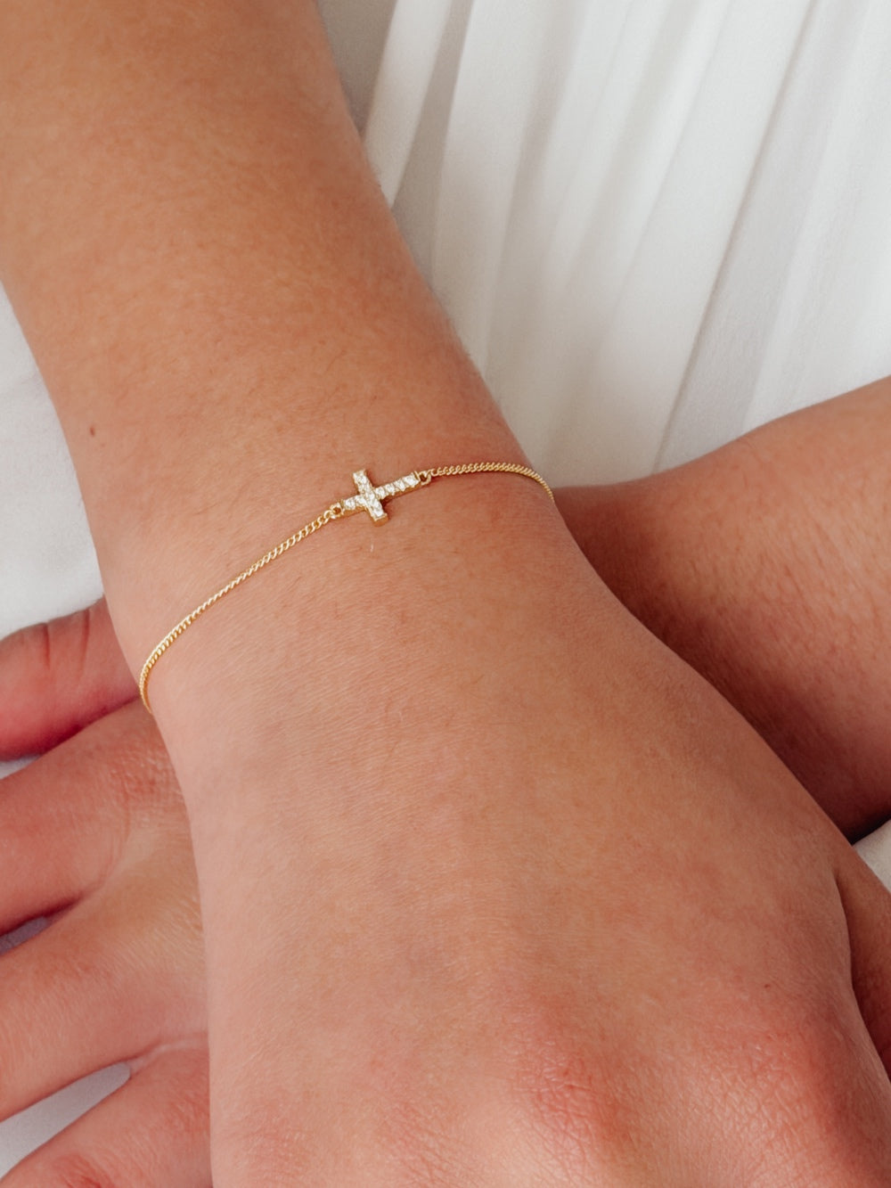 Girls gold cross bracelet with delicate star detail