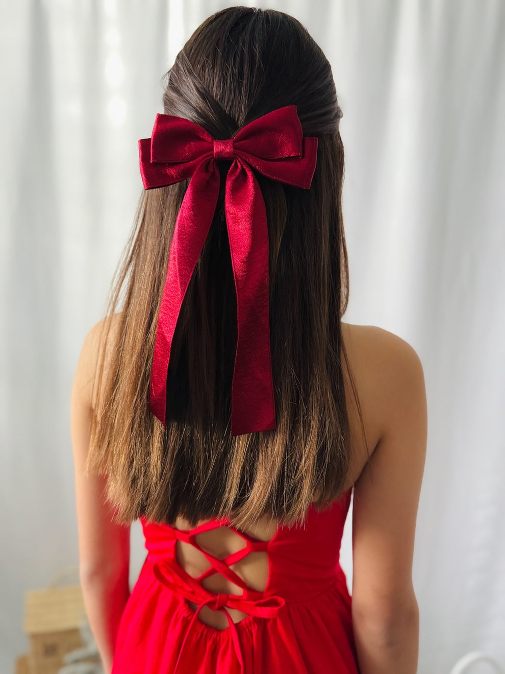 Red velvet Christmas bow styled in girl's hair for holiday event
