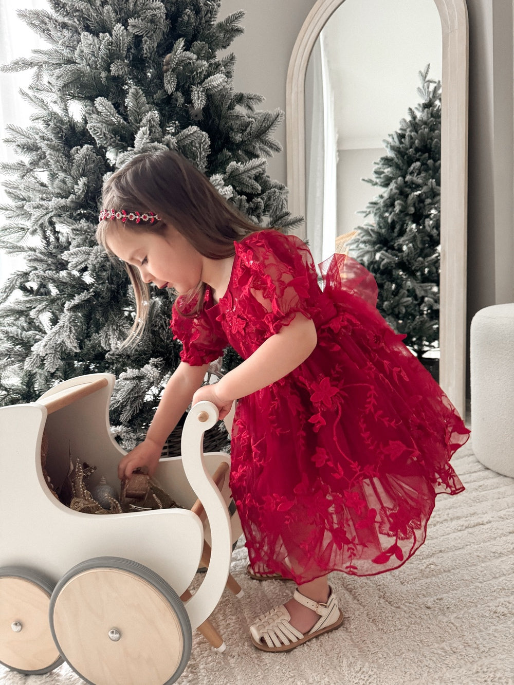 Side profile of red festive dress with sparkly floral accents
