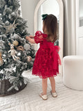 Red girls dress with puff sleeves and bow detail captured from behind
