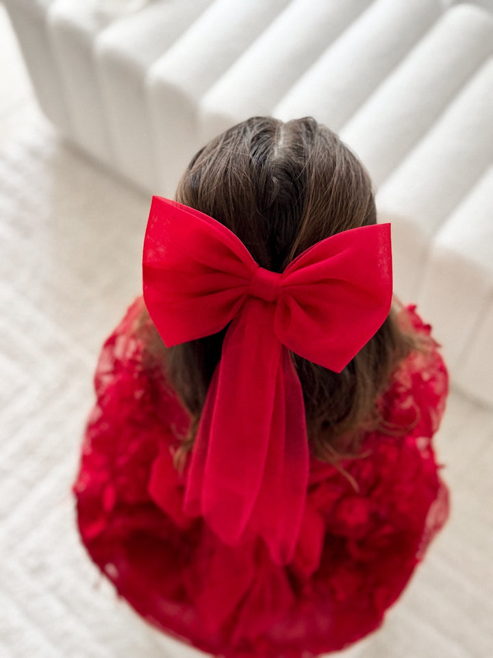 Red Tulle Christmas Bow with long tails styled on brunette girl