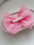 Bright pink wavy bow hair accessory for girls’ special occasions