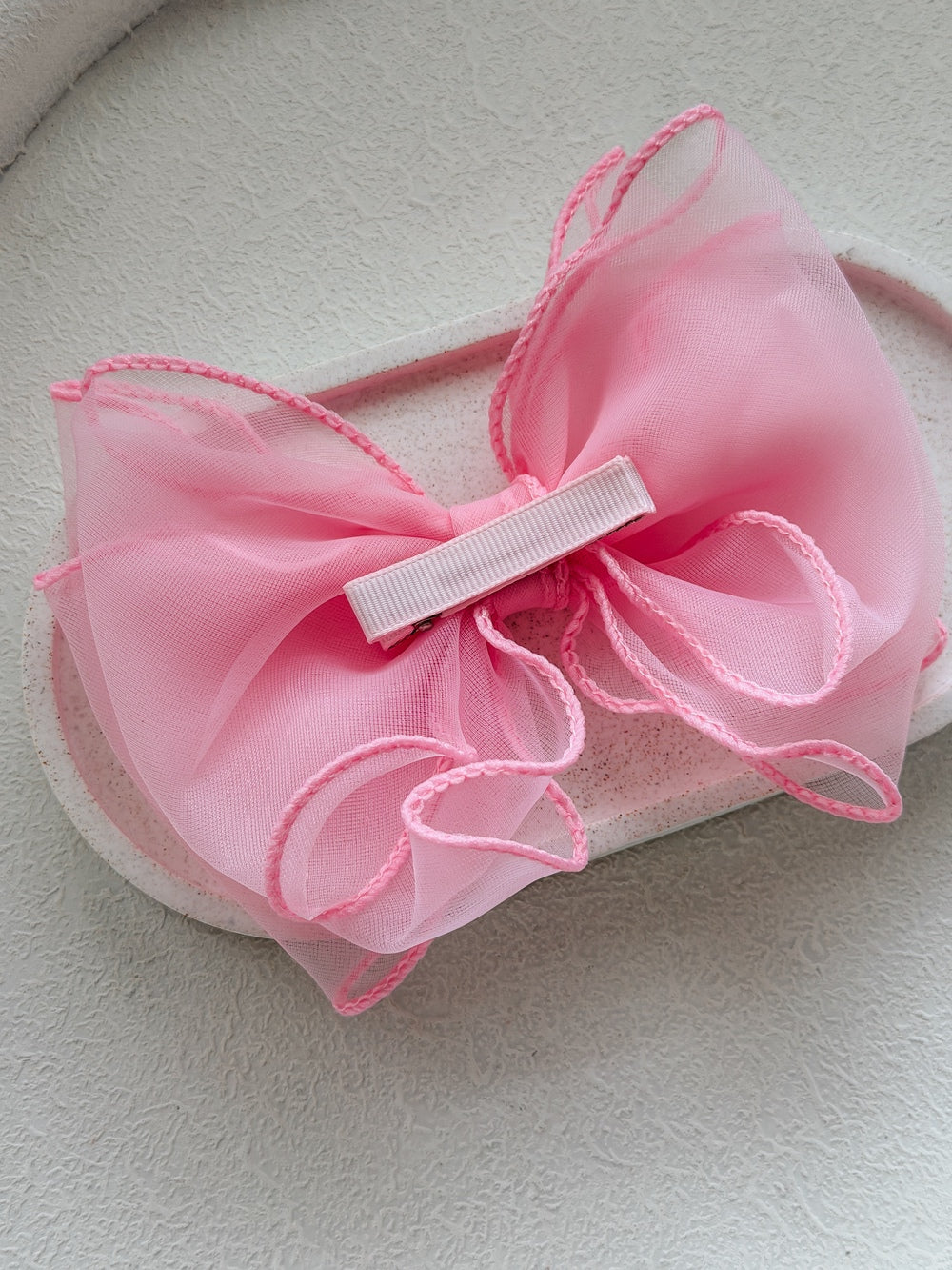 Bright pink wavy bow hair accessory for girls’ special occasions