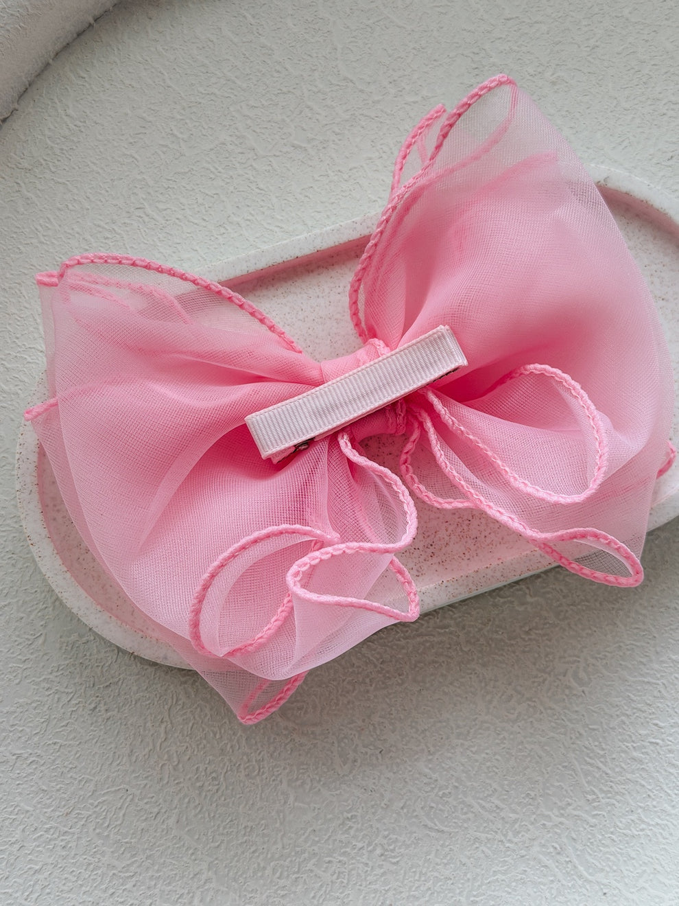 Bright pink wavy bow hair accessory for girls’ special occasions
