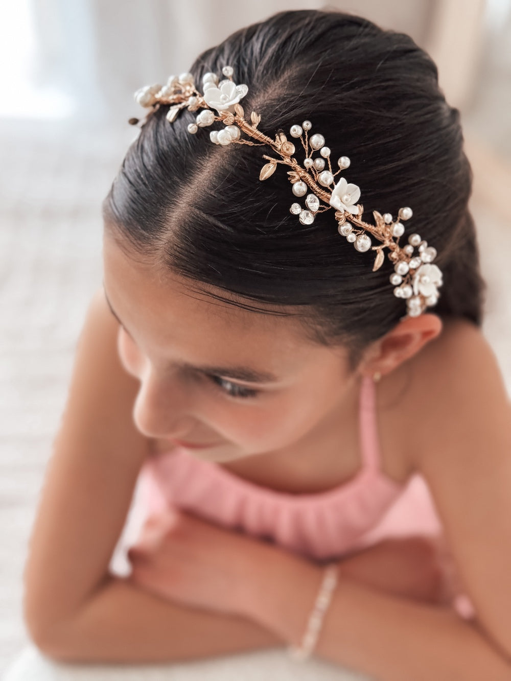 Girl wearing gold floral headpiece tied with ribbon at the back