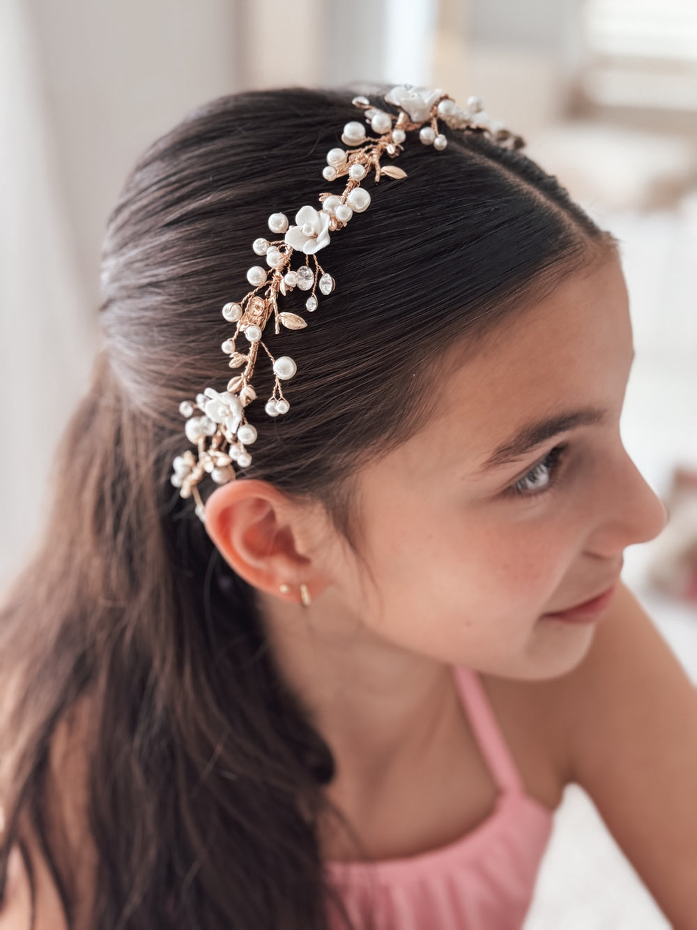 Close-up of gold flower girl headpiece with white flowers and diamantes