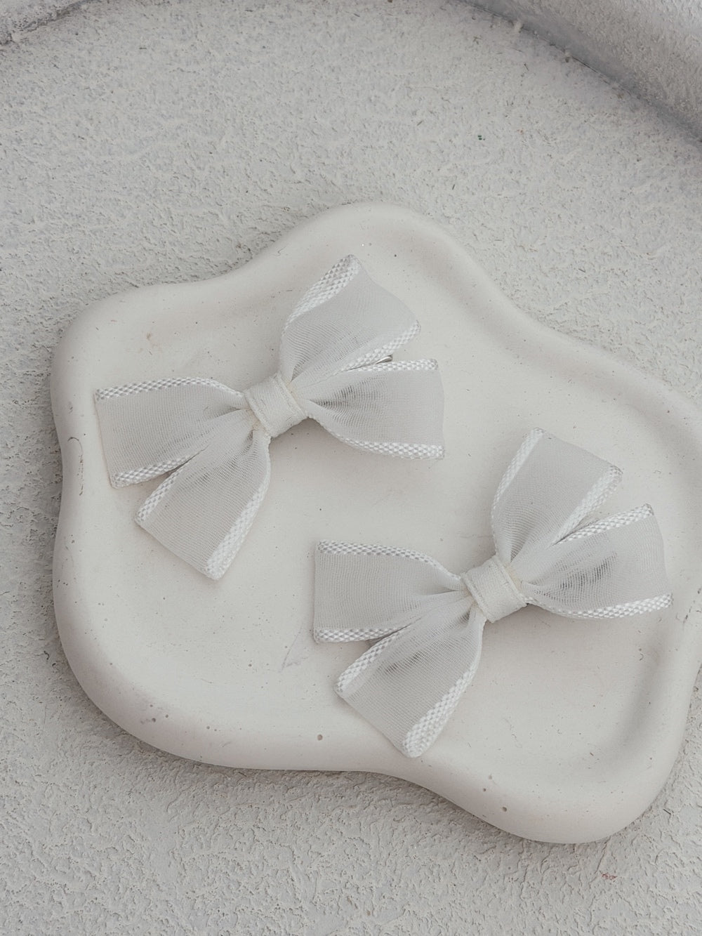 White ribbon bows with stitched edging