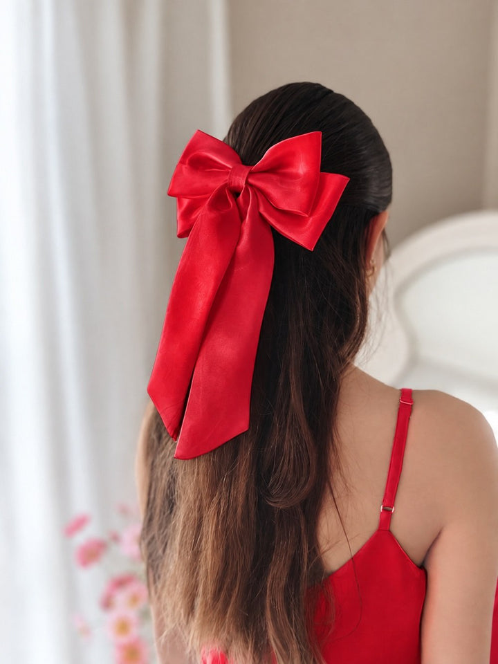 Amelie red christmas satin bow worn in a half-up hairstyle, showing the double loops and long tails.