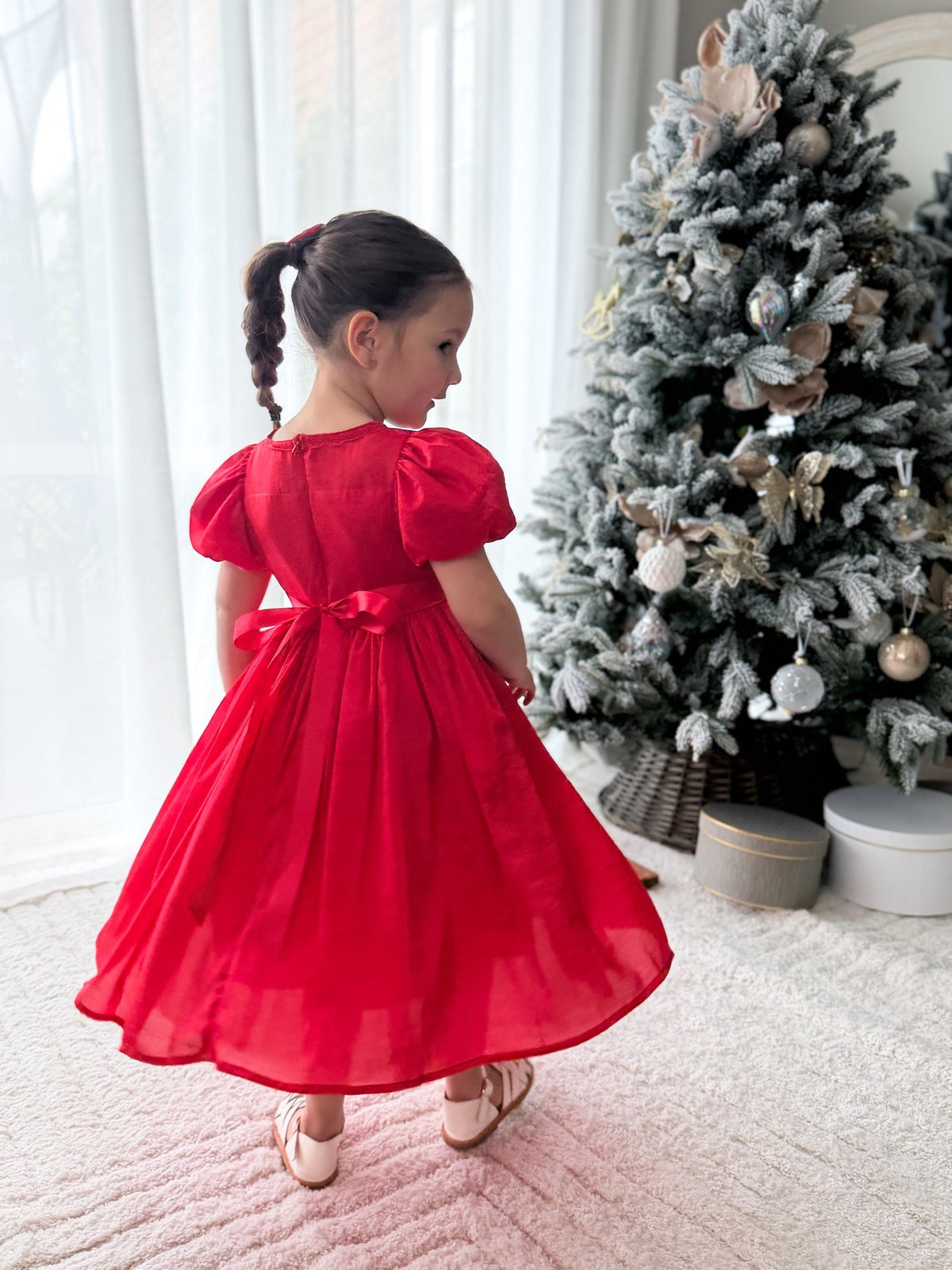 Back view of the Evangeline girls red Christmas dress showing puff sleeves, a red waist bow and the full skirt.