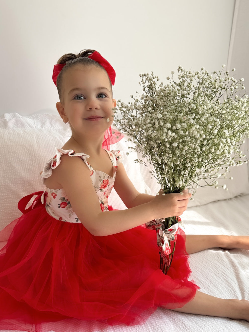 Close-up of floral print fabric on Stella Rose Girls Dress – soft red flowers on white background