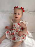 Detail shot of white cotton fabric with red and green floral pattern – Olive Christmas Romper