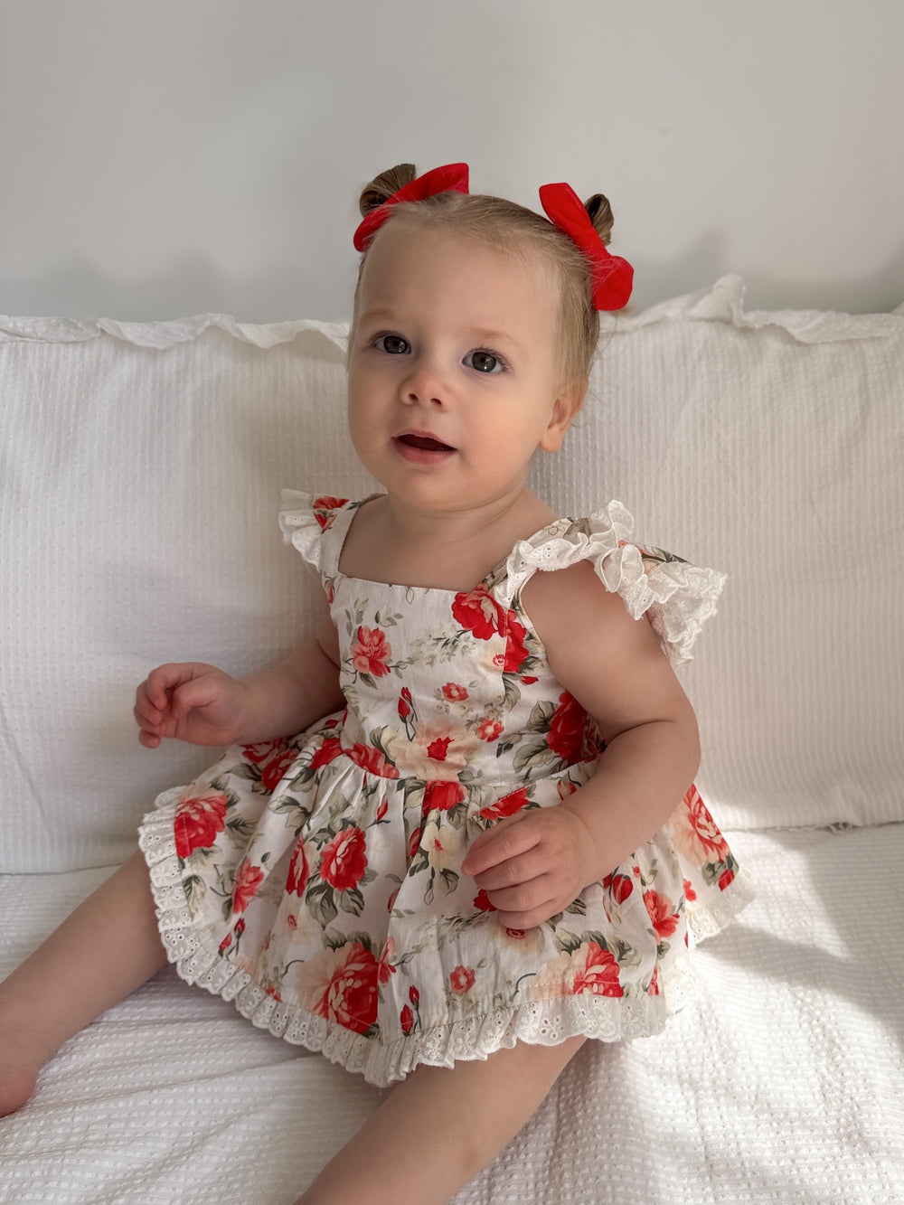 Detail shot of white cotton fabric with red and green floral pattern – Olive Christmas Romper