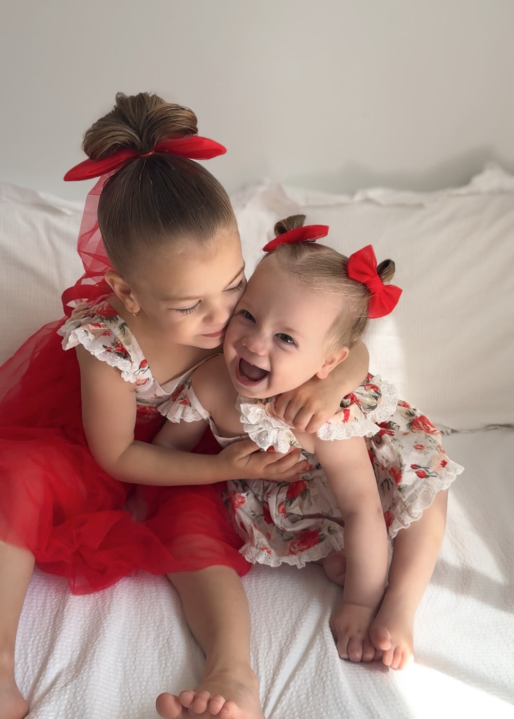 Olive Baby Girls Christmas Romper displayed with Stella Rose Dress for matching sister Christmas outfit