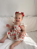 Baby girl wearing Olive Floral Christmas Romper with red and green roses sitting