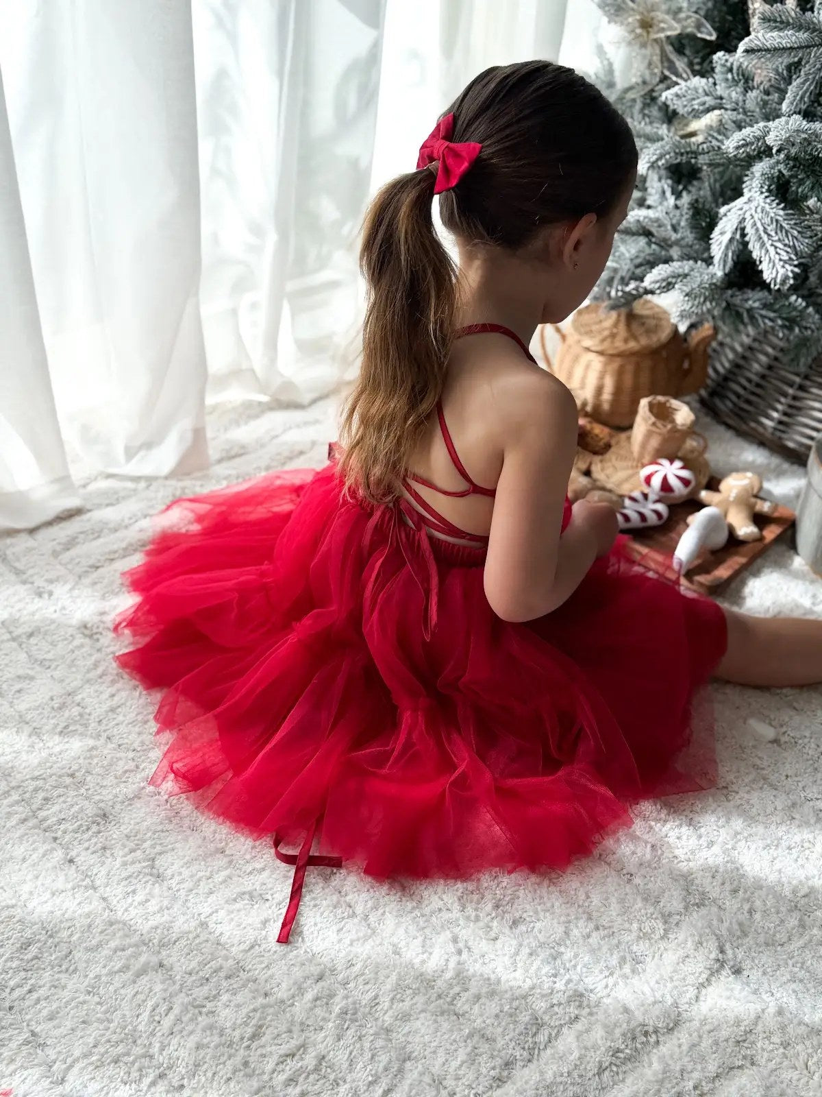 Back of the Juniper girls red Christmas dress showing the delicate crossing straps and full layered tulle skirt.