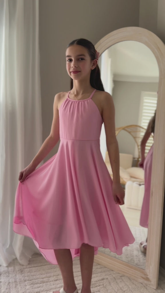 Tween girl twirling in pink Anna graduation dress