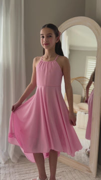 Tween girl twirling in pink Anna graduation dress