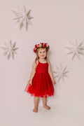 Full-length view of a girl styling the Winterberry flower crown with a red Christmas dress