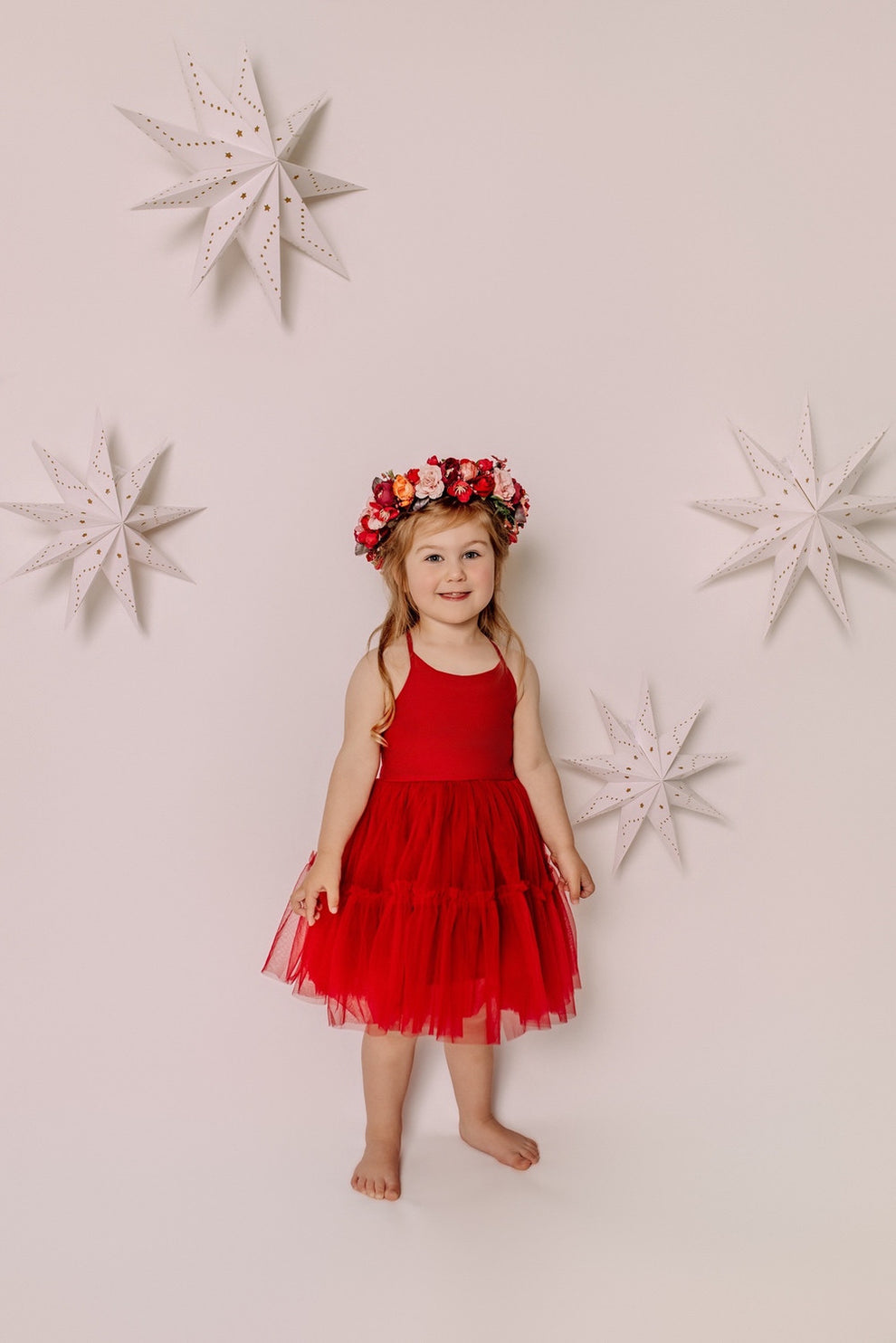 Full-length view of a girl styling the Winterberry flower crown with a red Christmas dress