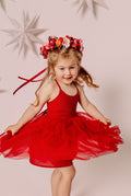 Girl twirling in a red dress with the Winterberry flower crown and long red ribbons