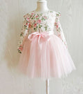 Detail of ruffle shoulders and floral bodice on girls long sleeved Audrey Rose party dress