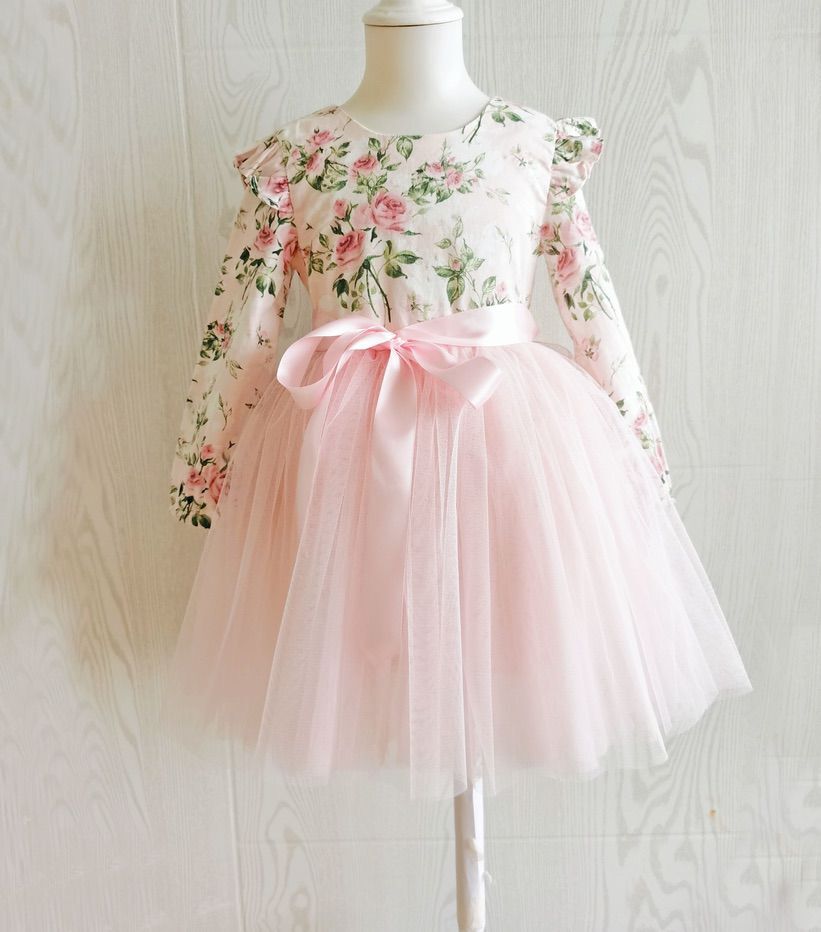 Detail of ruffle shoulders and floral bodice on girls long sleeved Audrey Rose party dress