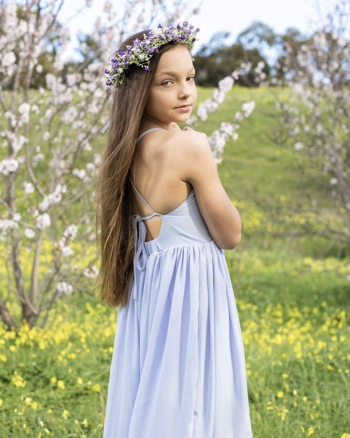 Girl wearing Sofia Dusty Blue Dress as a junior bridesmaid at a wedding